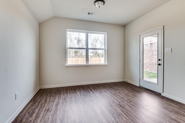 spare room featuring baseboards, plenty of natural light, visible vents, and dark wood-type flooring