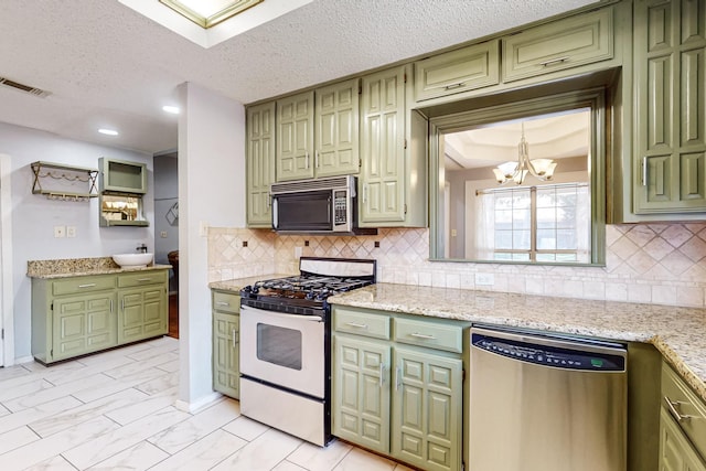 kitchen featuring green cabinetry, light stone counters, and appliances with stainless steel finishes