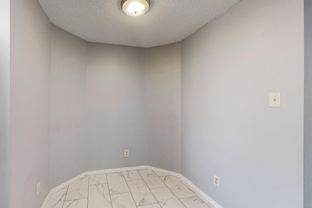 unfurnished room featuring a textured ceiling