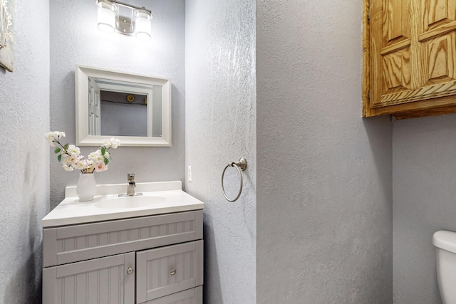 bathroom featuring toilet and vanity