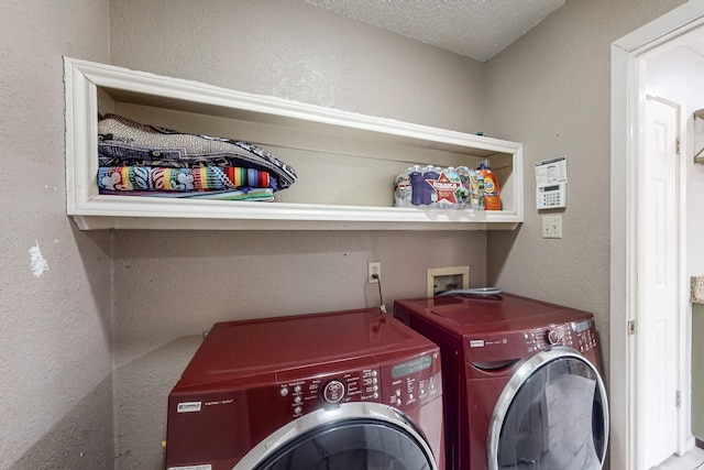 clothes washing area with a textured ceiling and separate washer and dryer