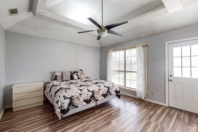 bedroom with ceiling fan, hardwood / wood-style floors, and a textured ceiling