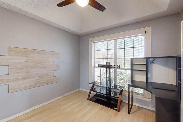 interior space featuring ceiling fan, light hardwood / wood-style floors, and a textured ceiling