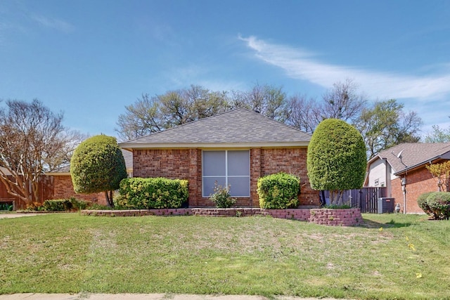 ranch-style home with cooling unit and a front lawn