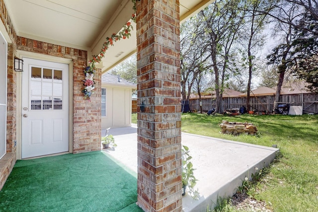 entrance to property with a lawn and a patio