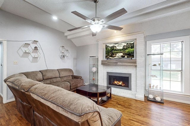 living room with hardwood / wood-style flooring, plenty of natural light, a textured ceiling, and lofted ceiling