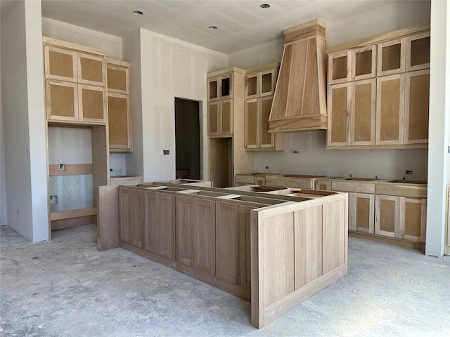 kitchen featuring a center island, light brown cabinetry, and custom range hood