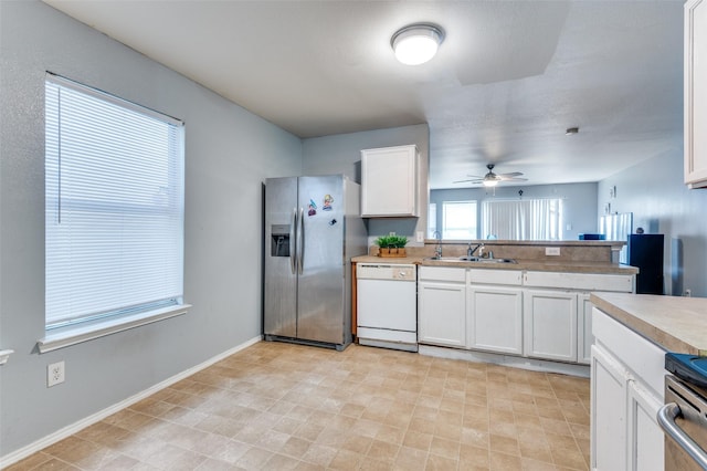 kitchen with stainless steel fridge, sink, white cabinetry, and dishwasher