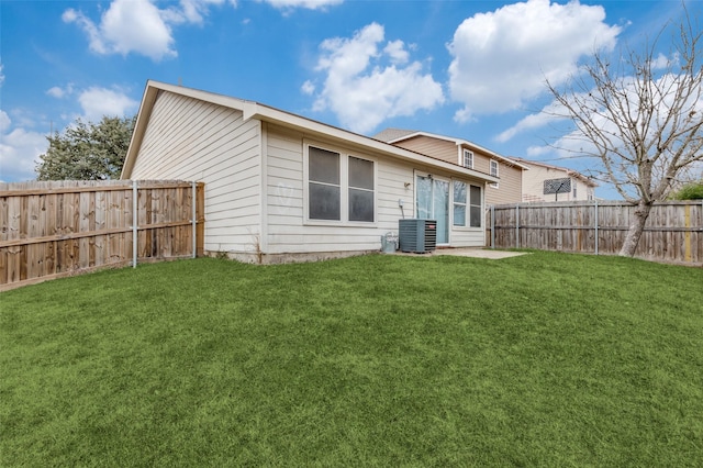 rear view of property featuring central air condition unit and a yard