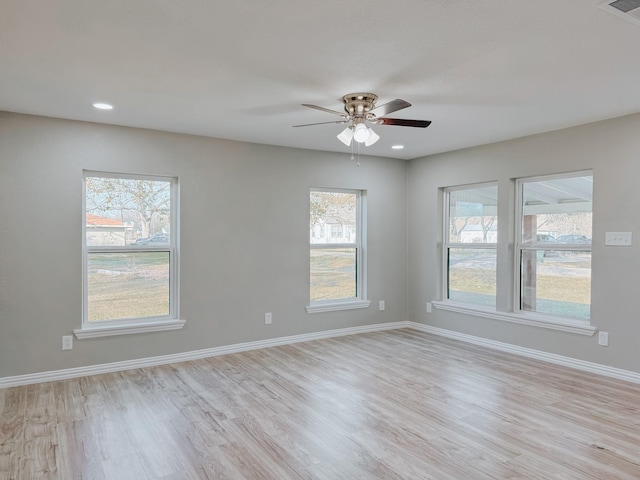 spare room featuring a wealth of natural light, light hardwood / wood-style flooring, and ceiling fan