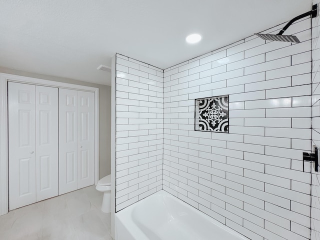 bathroom with tiled shower / bath and toilet