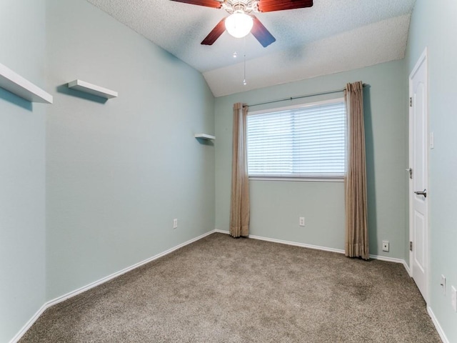 carpeted empty room with ceiling fan, vaulted ceiling, and a textured ceiling