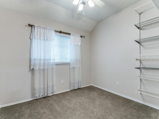 unfurnished room with lofted ceiling, ceiling fan, carpet floors, and a textured ceiling