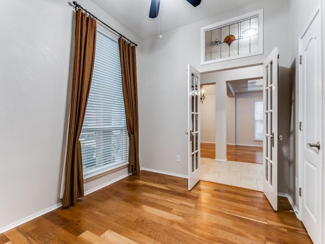 foyer featuring french doors, ceiling fan, and light wood-type flooring