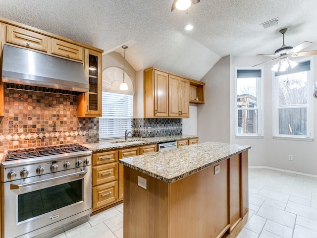 kitchen with lofted ceiling, sink, a kitchen island, pendant lighting, and stainless steel appliances