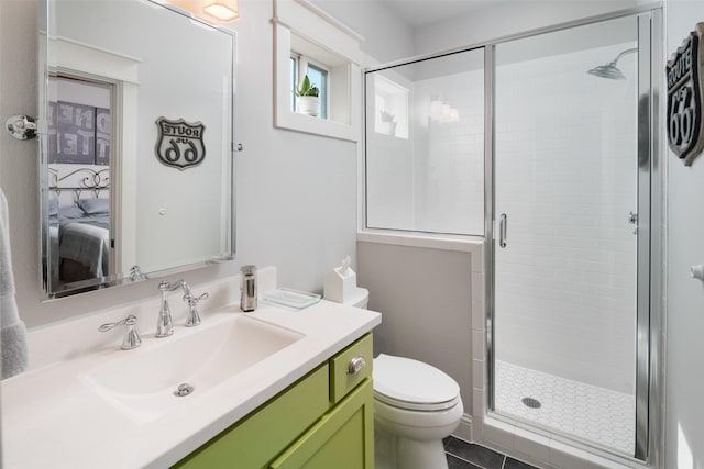 bathroom with a shower with door, toilet, tile patterned floors, and vanity