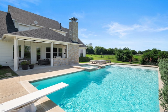 view of pool featuring an in ground hot tub, ceiling fan, a diving board, and a patio