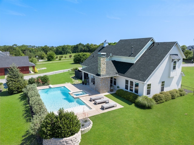 view of swimming pool featuring an in ground hot tub, a patio, and a lawn