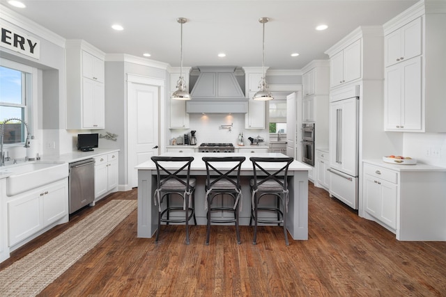 kitchen featuring custom exhaust hood, a kitchen island, white cabinets, and stainless steel appliances