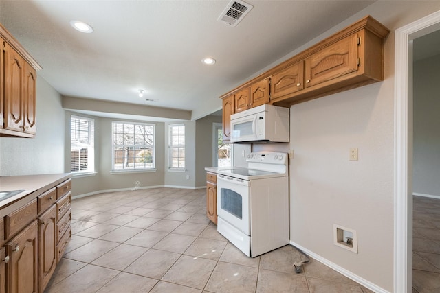 kitchen with white appliances and light tile patterned floors