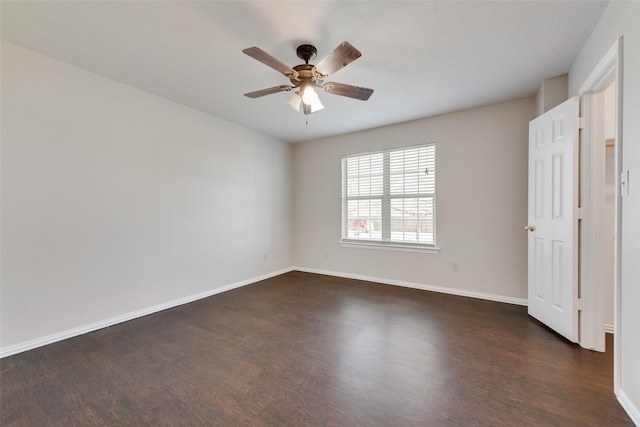 spare room featuring dark wood-type flooring and ceiling fan