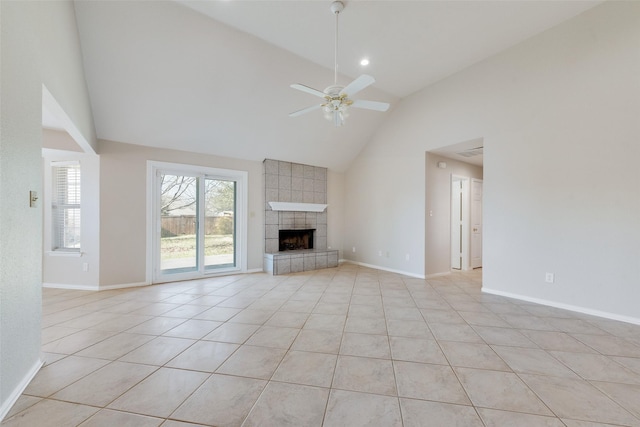 unfurnished living room featuring ceiling fan, a tiled fireplace, light tile patterned floors, and lofted ceiling