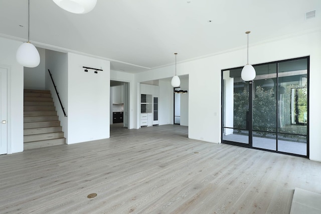 unfurnished living room with light hardwood / wood-style flooring and ornamental molding