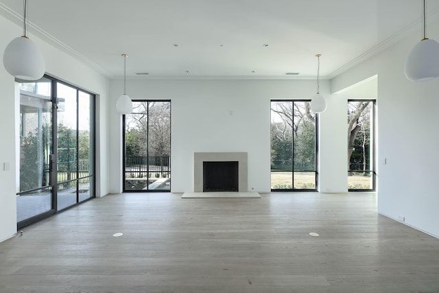 unfurnished living room featuring hardwood / wood-style floors and crown molding