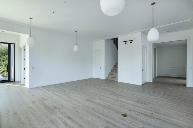 unfurnished living room with light hardwood / wood-style floors and ornamental molding