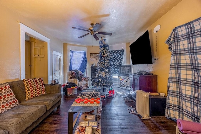 living room with ceiling fan and dark wood-type flooring