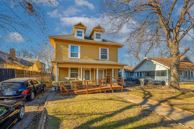 view of front facade featuring covered porch and a front lawn