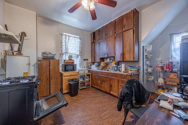 kitchen featuring wood-type flooring, gas range, and ceiling fan