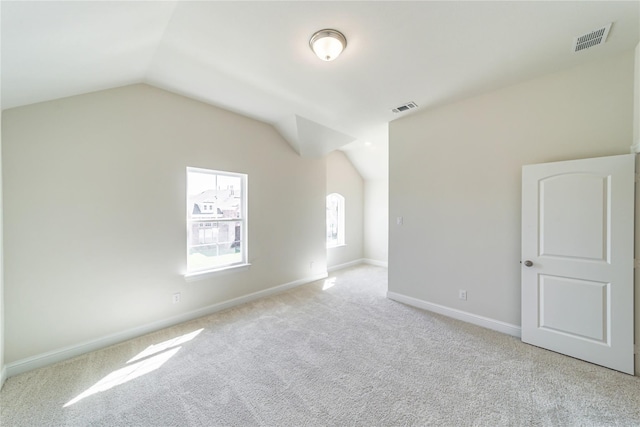 carpeted spare room with lofted ceiling