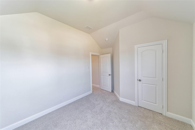 interior space with lofted ceiling and light carpet