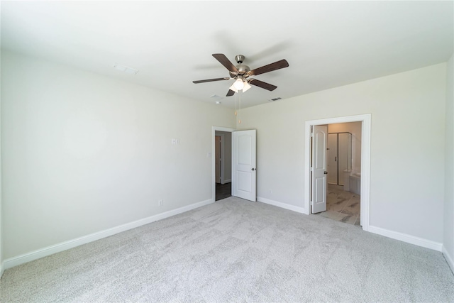 unfurnished bedroom with ensuite bathroom, light carpet, and ceiling fan