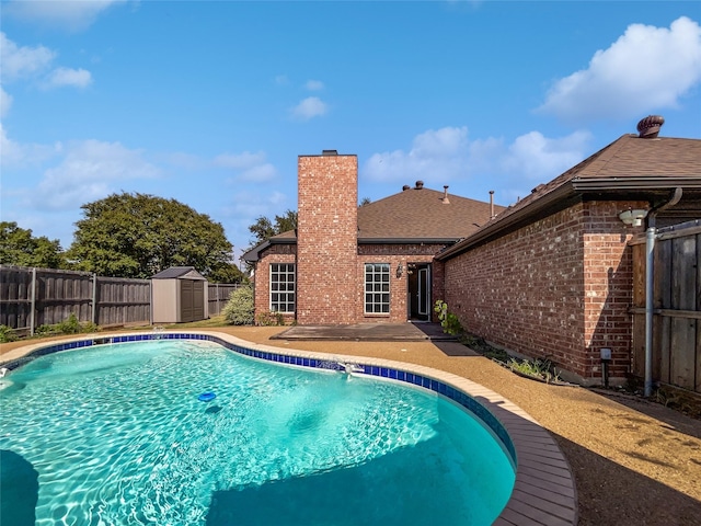 view of swimming pool featuring a patio area and a shed