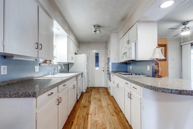 kitchen with white cabinets, light hardwood / wood-style flooring, appliances with stainless steel finishes, and sink