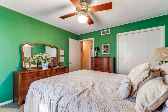 bedroom featuring a closet, ceiling fan, light colored carpet, and a textured ceiling