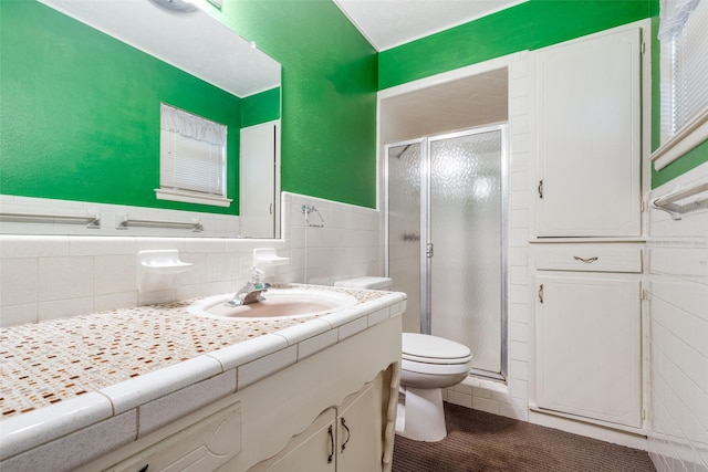 bathroom with an enclosed shower, tile patterned floors, tile walls, toilet, and vanity