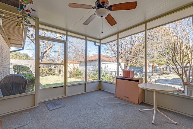 unfurnished sunroom featuring ceiling fan