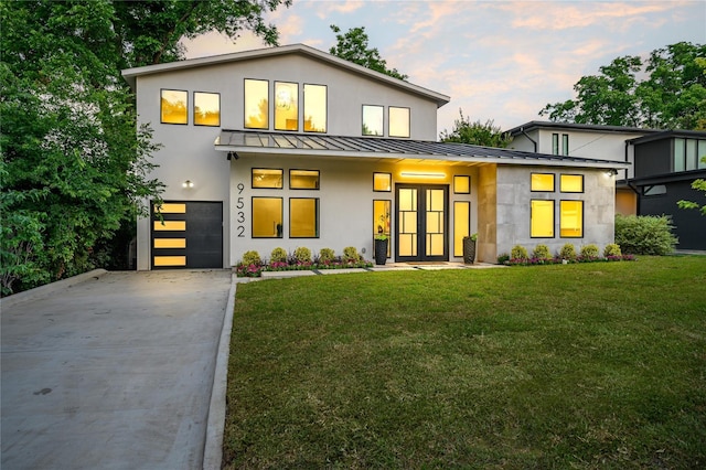 view of front of home with a garage and a lawn