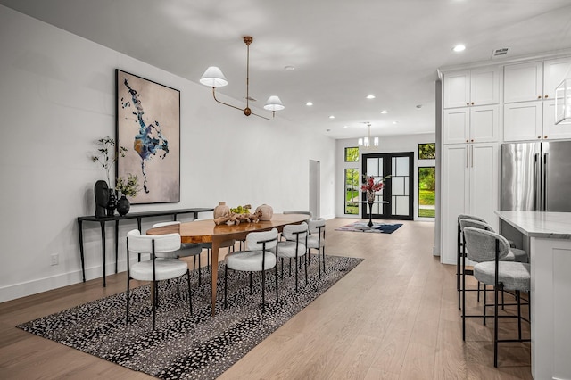 dining room with a chandelier and light hardwood / wood-style flooring