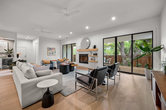 living room featuring ceiling fan, beverage cooler, and light hardwood / wood-style flooring