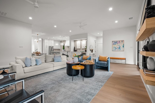 living room featuring ceiling fan and light hardwood / wood-style floors