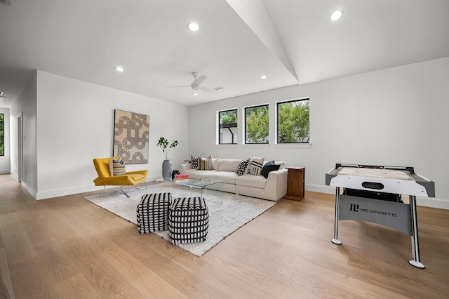 living room with vaulted ceiling, light hardwood / wood-style floors, and ceiling fan