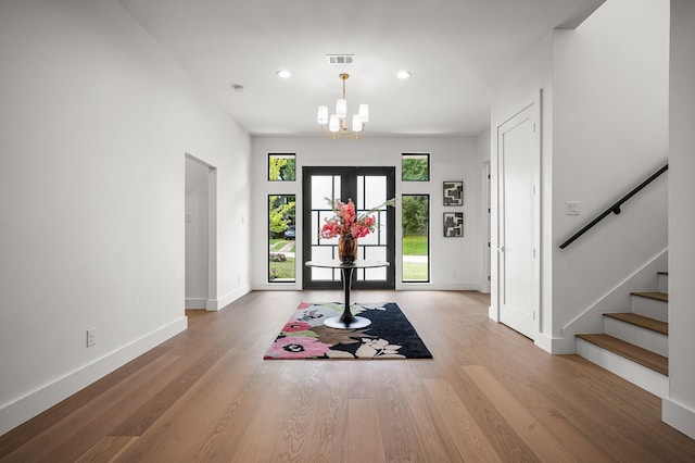 entryway with hardwood / wood-style flooring and an inviting chandelier