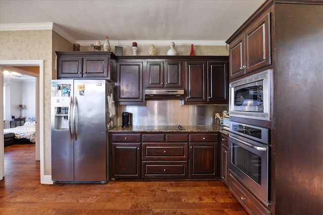 kitchen featuring dark brown cabinets, dark hardwood / wood-style flooring, dark stone counters, and stainless steel appliances