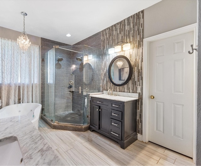 bathroom with a shower with shower door, vanity, and an inviting chandelier