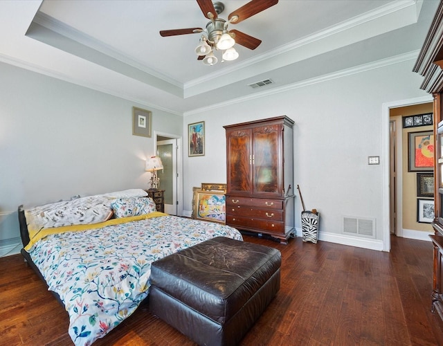 bedroom with ceiling fan, dark wood-type flooring, a tray ceiling, and ornamental molding