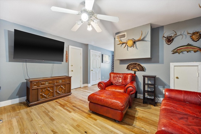 living room with light hardwood / wood-style floors and ceiling fan